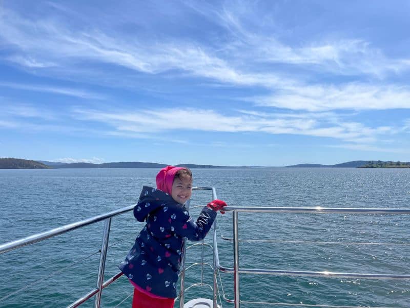Our daughter smiling while whale watching a tthe back of the boat. 