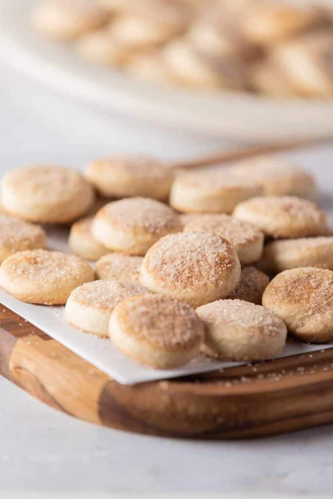 Plate full of round Pan de Polvo , Mexican Shortbread Cookies sprinkled with connamon sugar.