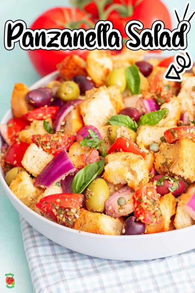 A colorful bowl of panzanella salad filled with toasted bread cubes, red and green olives, tomatoes, red onion, capers, and fresh basil. The text "Panzanella Salad" appears above the bowl with an arrow pointing toward the salad.