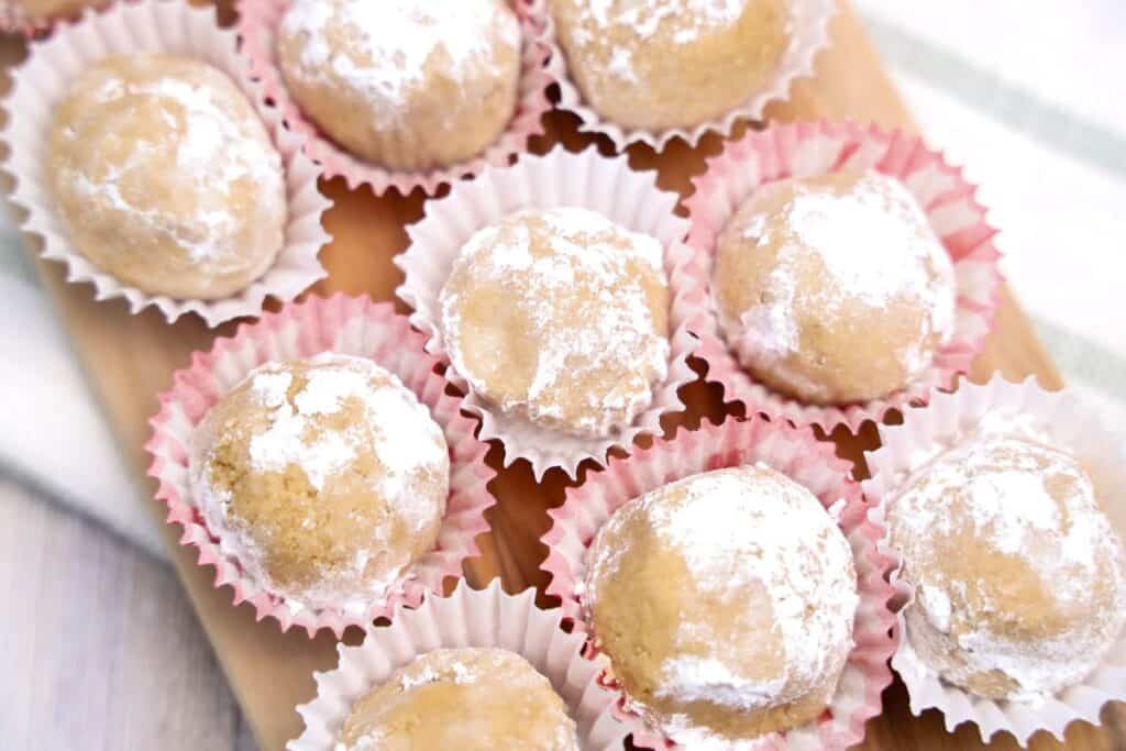 Nine small peanut putter balls rolled in icing sugar in mini cupcake liners. 