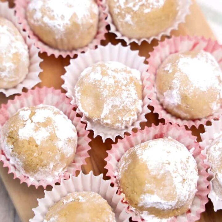 Nine small peanut putter balls rolled in icing sugar in mini cupcake liners.