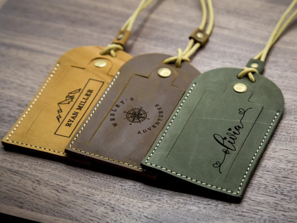 Three leather luggage tags personalized with engraved names. Fun travel items