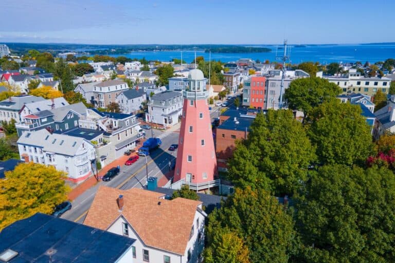 Aerial view of the pink Portland Observatory tower and. homes on the hill.