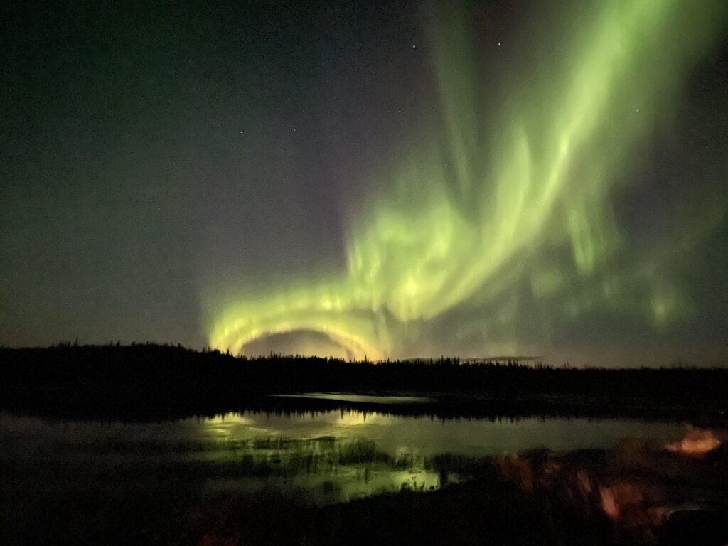 Half circle aurora swirling across the sky above Prosperous Lake, NT.