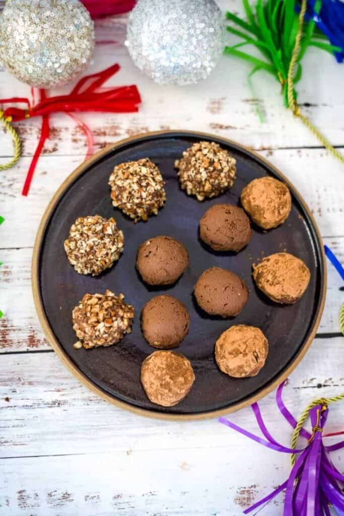 Plate with pumpkin chocolate truffles rolled in pecans, cocoa, and plain.