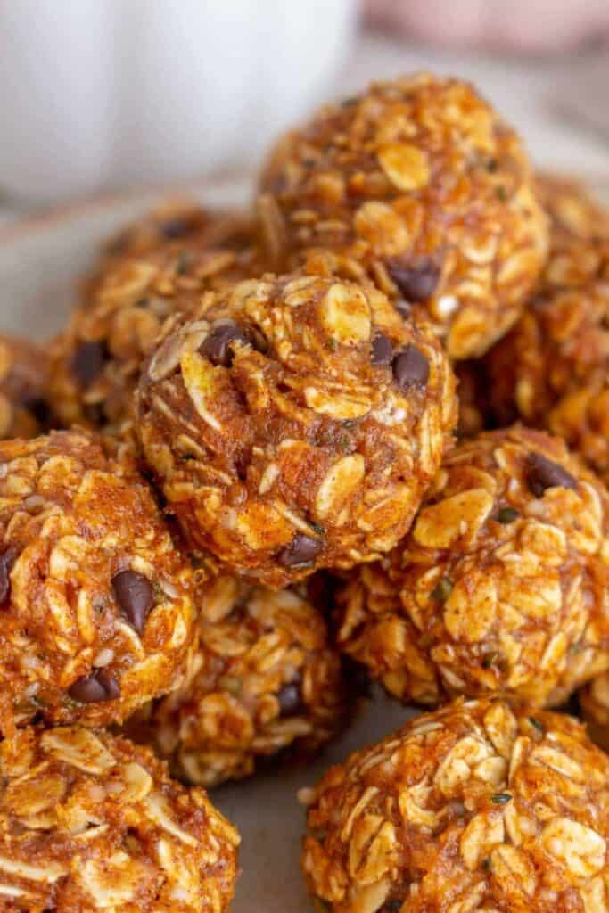 Close up of a pile of small round pumpkin protein balls made with oats, pumpkin and chocolate chips. 