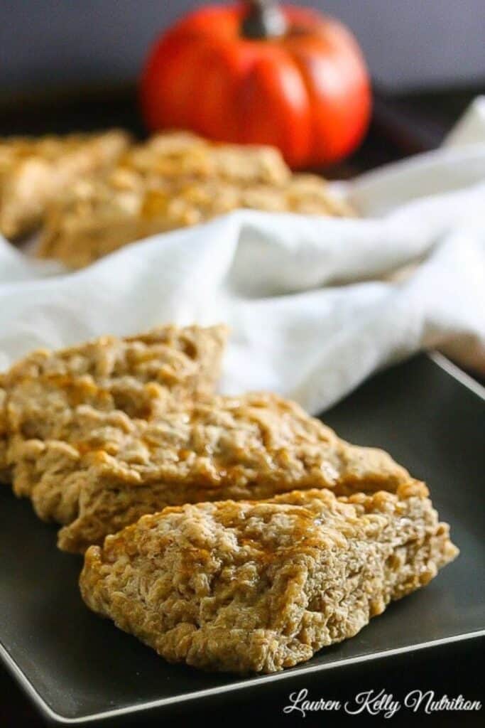 Close up of three traingle shaped pumpkin spice scones on a plate. 