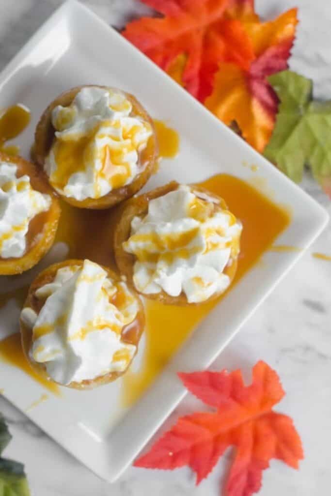 Four Caramel Pumpkin Cookie cups on a square plate. 