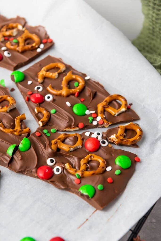 Broken pieces of chocolate christmas bark with reindeer pretzels. 