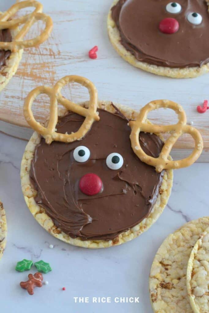 Rice cake reindeer, with pretzel antlers, nuttella and smartie nose.