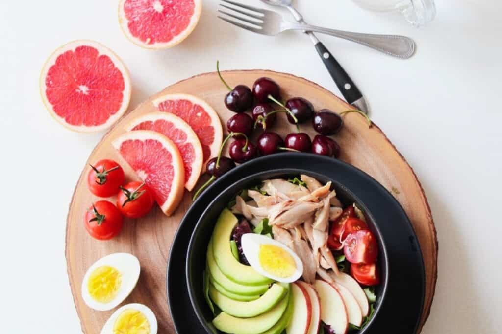 Plate of cut up fruit, vegetables, meat and eggs for road trip snacks