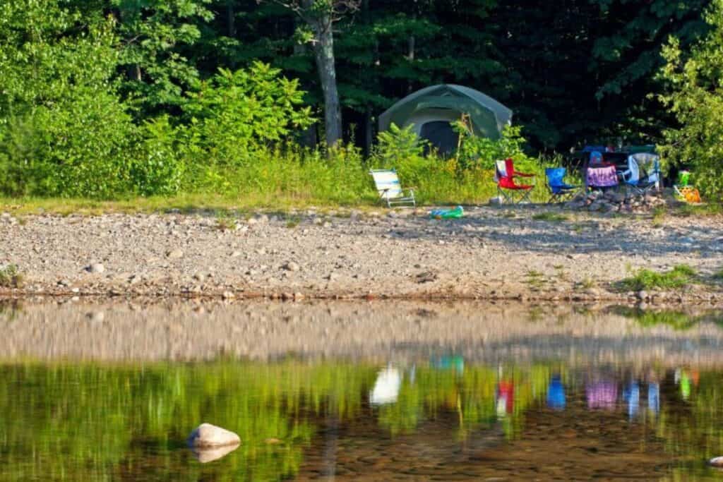 Tent and camp chairs along the Saco River. Saco River Campgrounds.