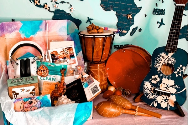 Safiya's World Music Playlist subscription box fillled with music and products from Africa; headphoones, Ajiri Tea, passport, ticket, art work.
