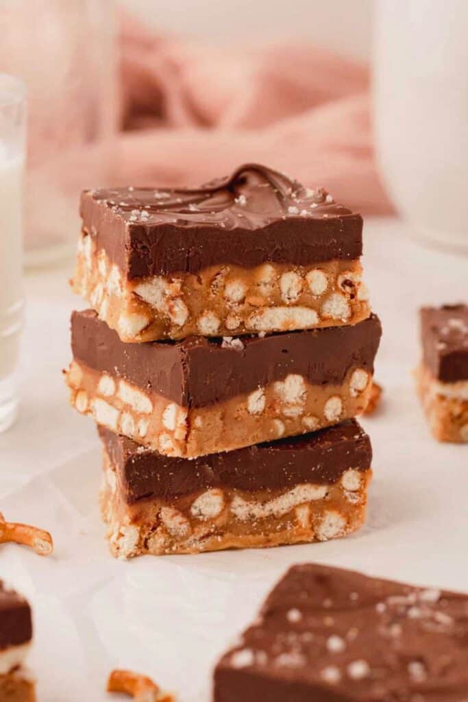 A stack of three thick dessert bars with a crunchy pretzel filled base and a smooth chocolate layer on top. The sweet and salty bars are finished with a sprinkle of coarse salt and make easy fall desserts for a crowd.