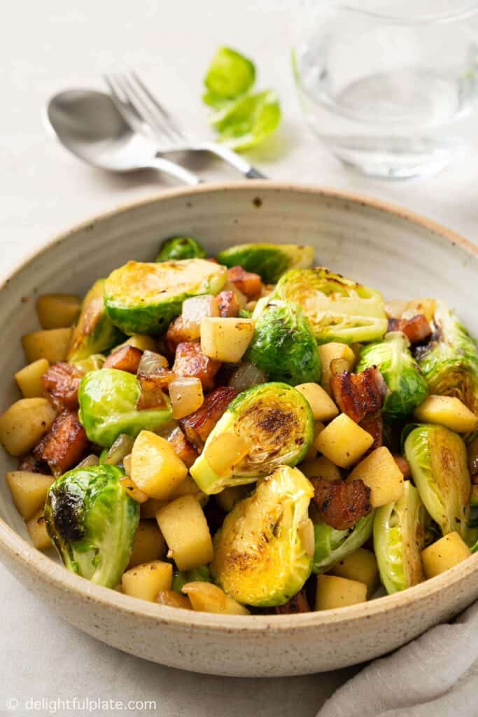 Bowl of sauteed brissels spouts with bacon and apples.