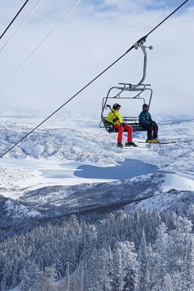 Two skiiers on a ski lift in Park City in winter. 
