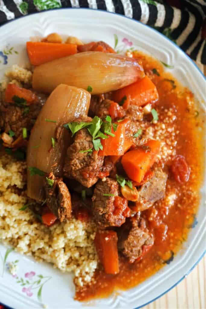 Close of of Greek Beef stew with shallots, carrots over couscous. 