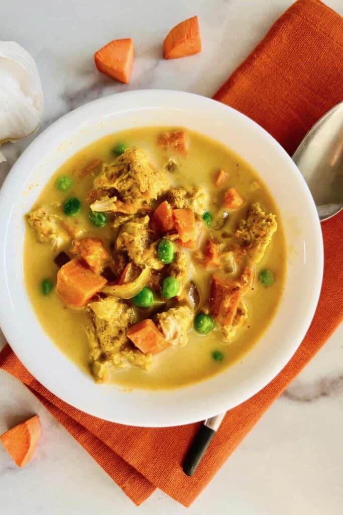 Bowl of sweet potato, chicken curry with peas. 