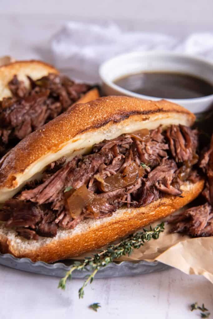 Two crusty mini sandwich baguettes filled with slow cooked beef for beef dip sandwiches.  