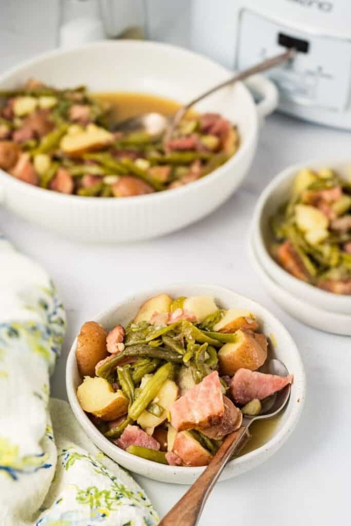 Bowl of ham, potatoes and green beans cooked in a slow cooker. 