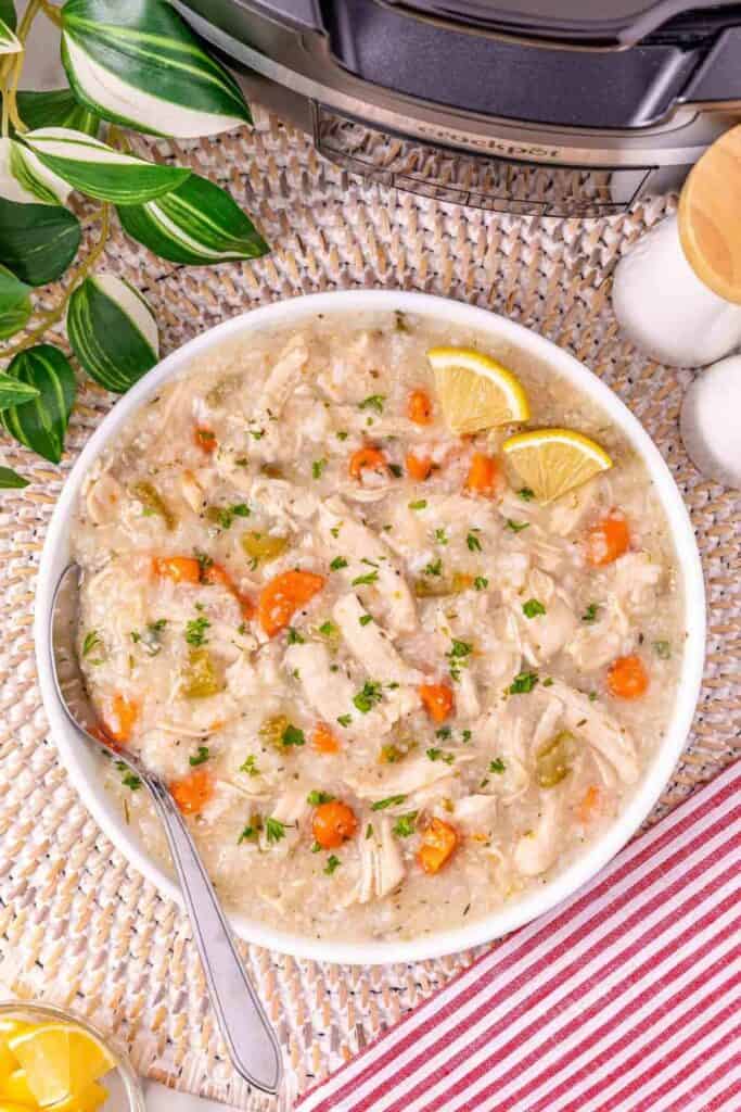 Leftover turkey and rice soup with shredded turkey carrots celery and rice is served in a creamy broth. This hearty crockpot soup is topped with fresh parsley and lemon wedges.