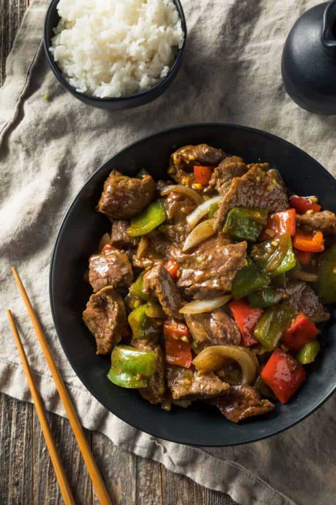 Bowl of pepper steak with red and green peppers. 