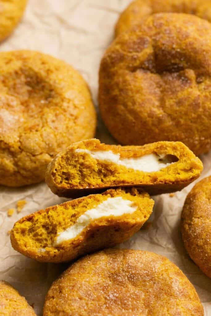 Soften pumpkin cookies broken open to reveal cream cheese filling.