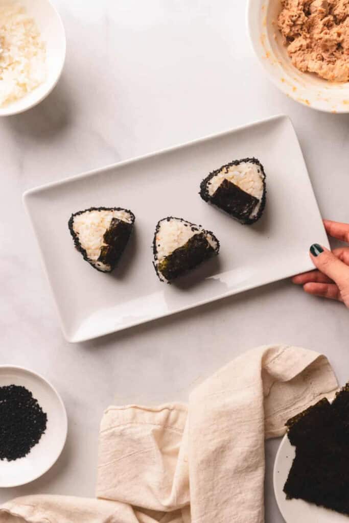 Three triangular spicy tuna Onigiri, a Japaense riceball snack. 