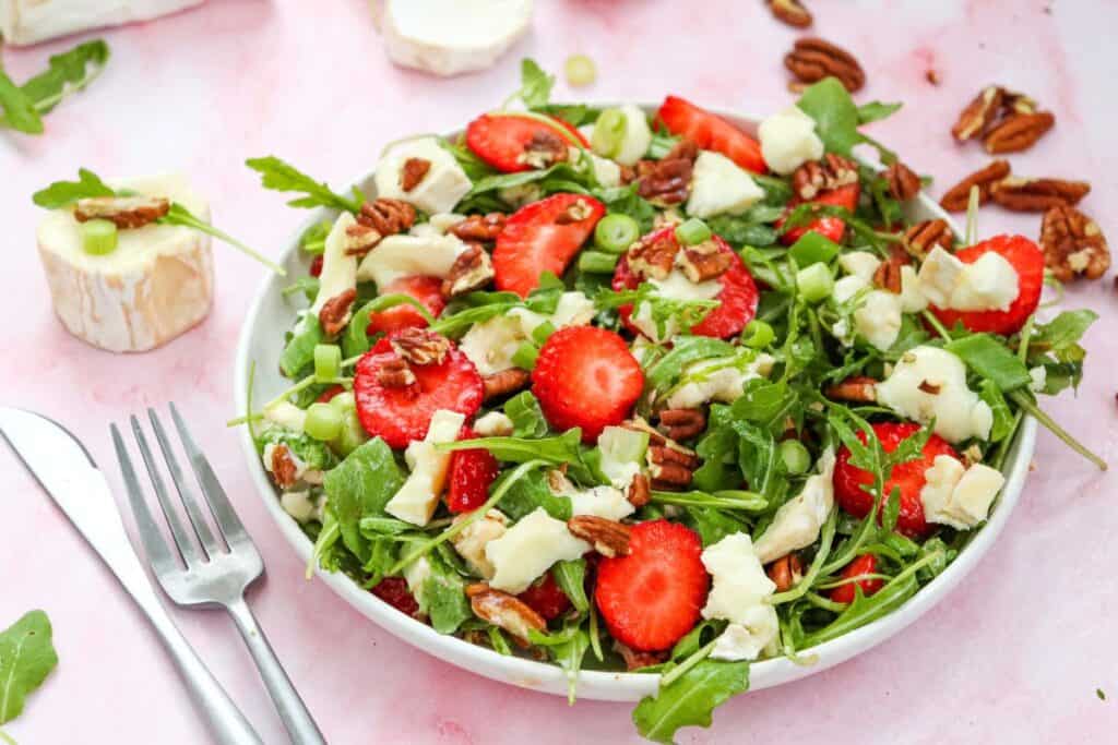 Bowl of strawberry, goat cheese, arugula, pecan salad. 