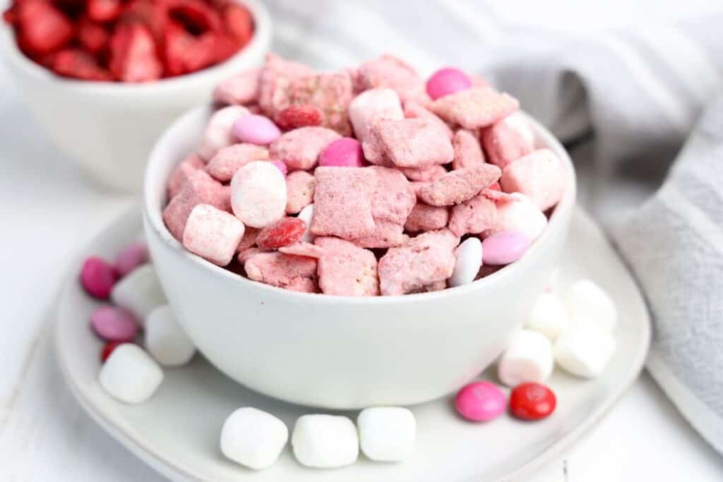 A medium sized bowl of Strawberry Puppy Chow snack mix.