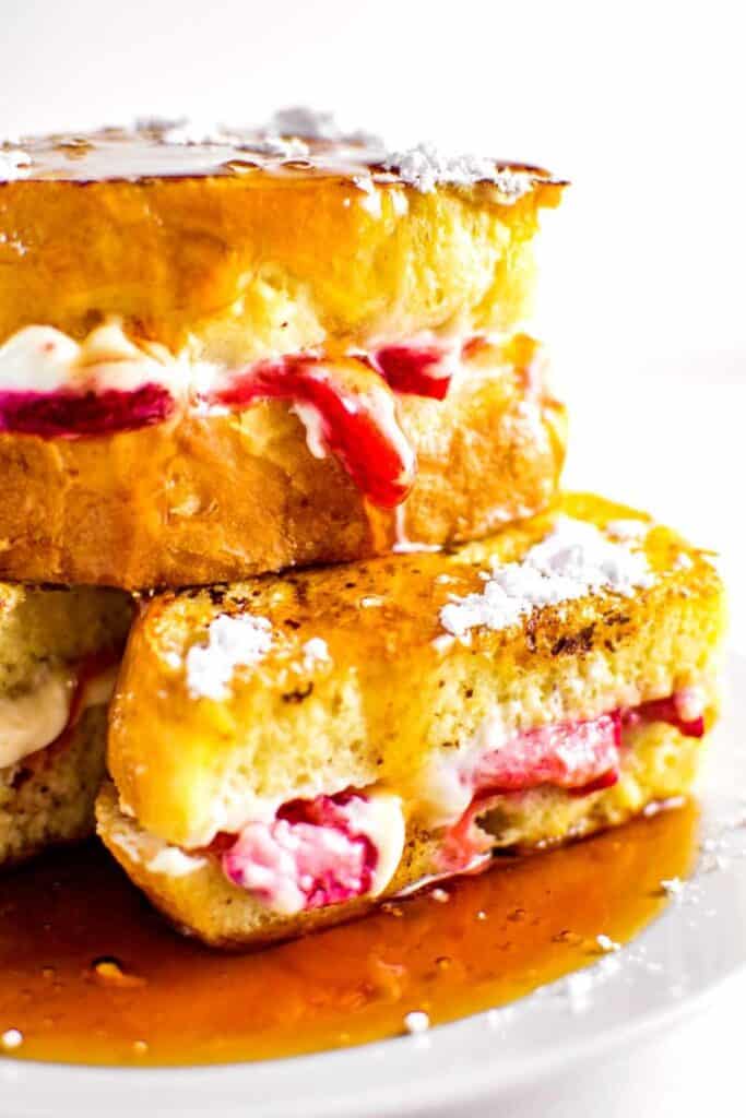 Stack of thick french toast stuffed with strawberries and cream cheese filling.