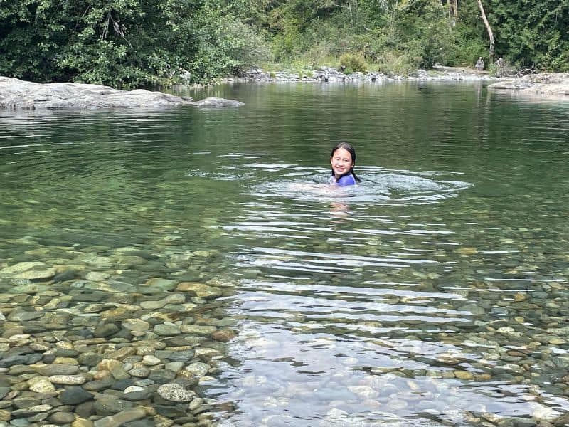 Young girl swimming in the river at Sooke Potholes, Vancouver Island Canada.