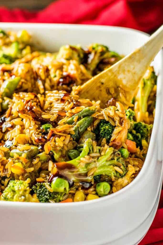 Casserole dish filled with chicken teriyaki, rice, carrots, broccoli & peas. 