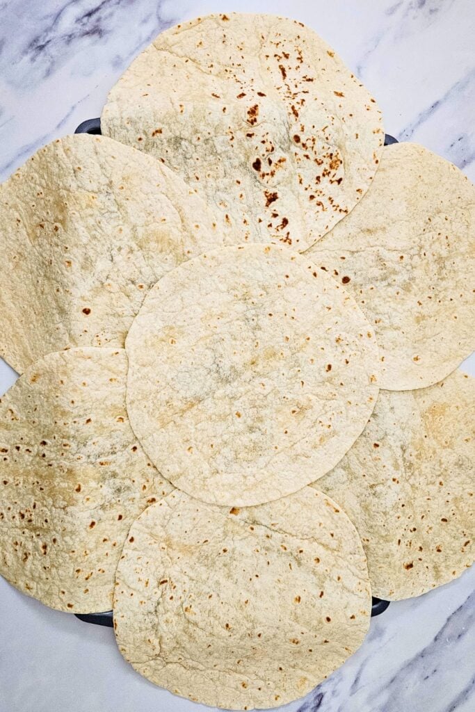 Baking pan covered in tortillas. 