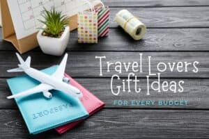 Travel Lovers Gift Ideas with toy airplane, passports, roll of money on wooden background.