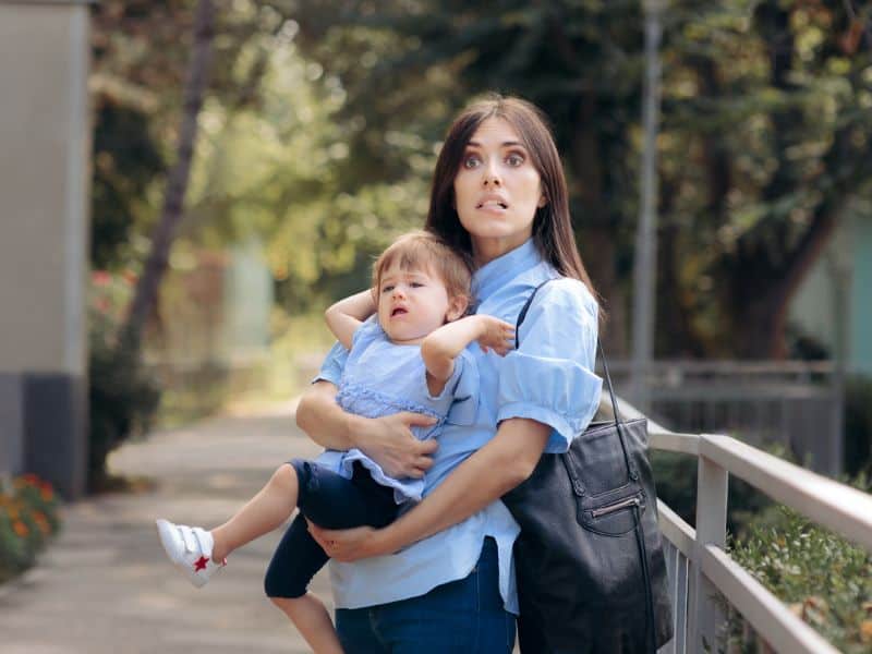 Mom looking stessed holding crying toddler