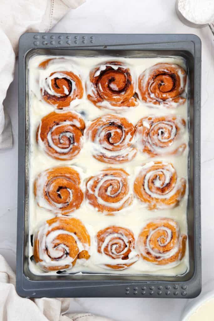 Pan of iced pumpkin cinnamon rolls. 