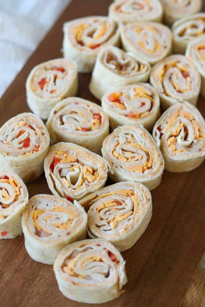 Rows of cut slices of turkey and cheese pinwheel roll ups. 