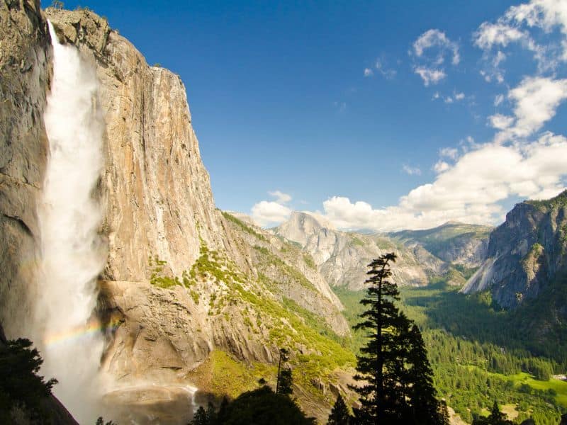 View of Upper Yosemite falls looking down into Yosemite Valley with Half Dome in the distance.