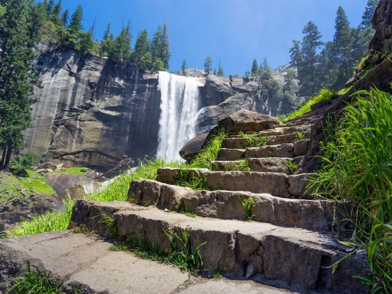 Stone staircase trail with Vernal Fall in Yosemite on the left.