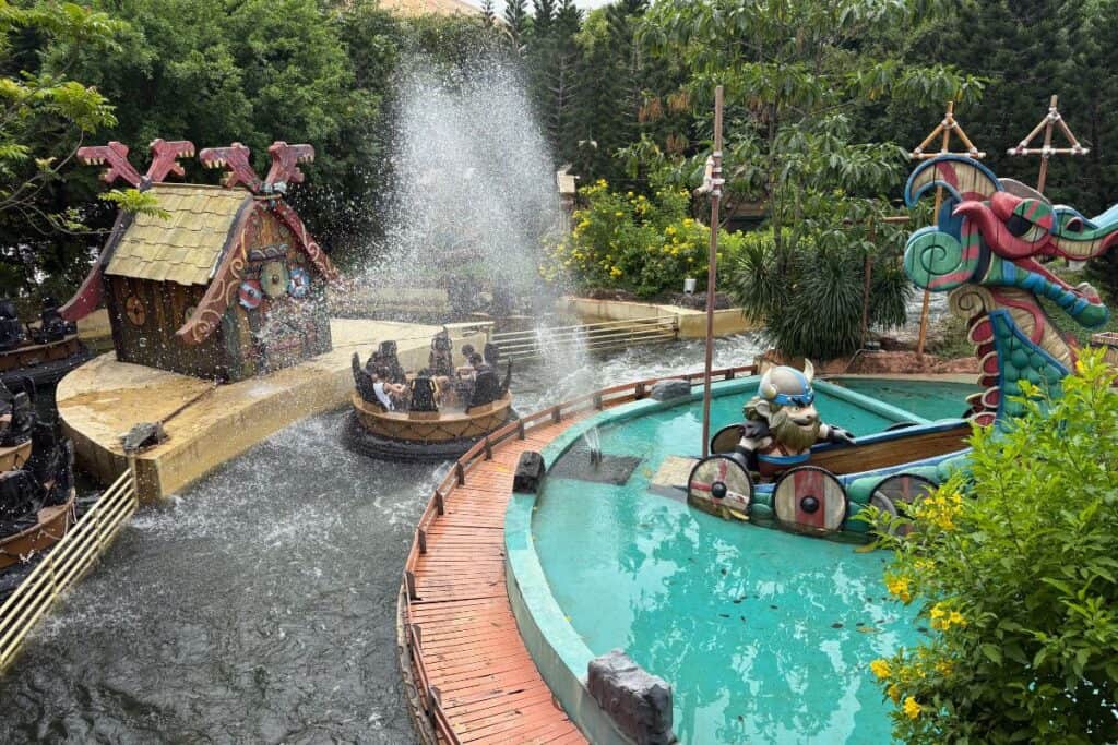 Viking themed river amusement ride, with people getting sprayed by a jet of water. 