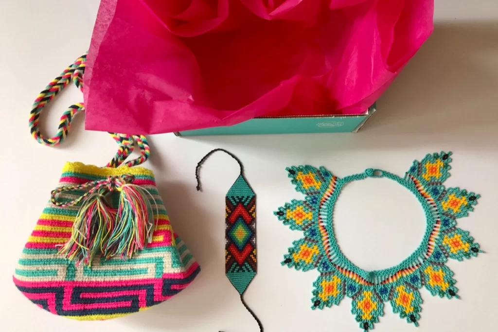Wanderkarma travel subscription items; beaded necklace and bracelet, handwoven colorful bag.