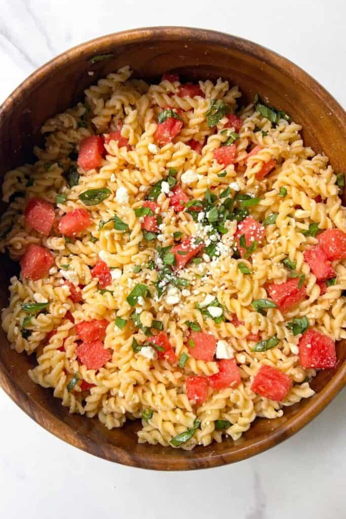 Rotini Watermelon feta and basil salad in a wooden bowl. 