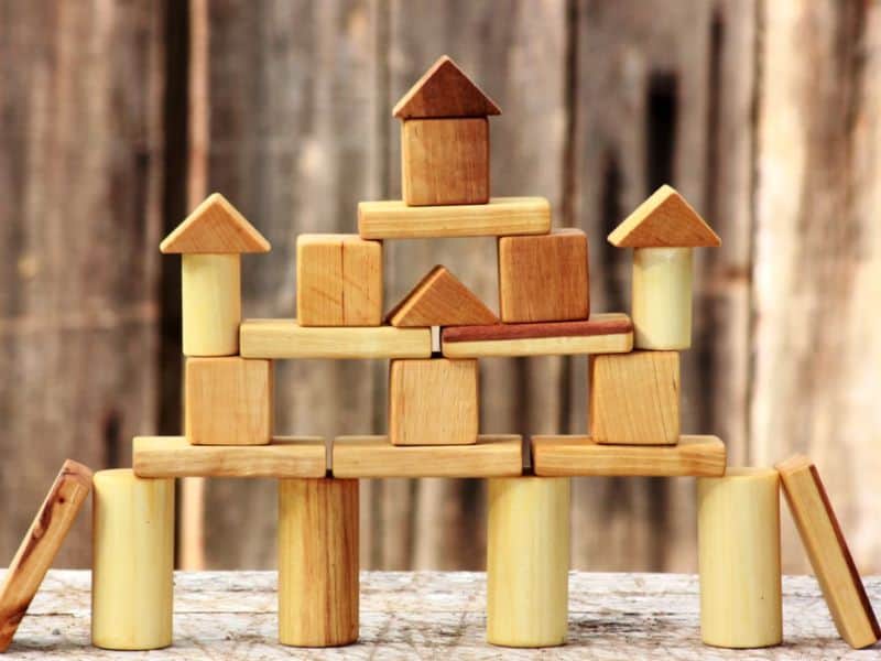 Stack of all natural wooden blocks in round cylinders, rectangles and triangles. 