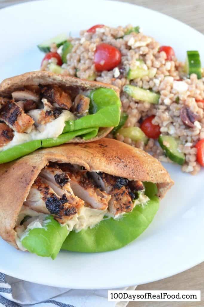 Two pita sandwiches with grilled chicken and lettuce. 